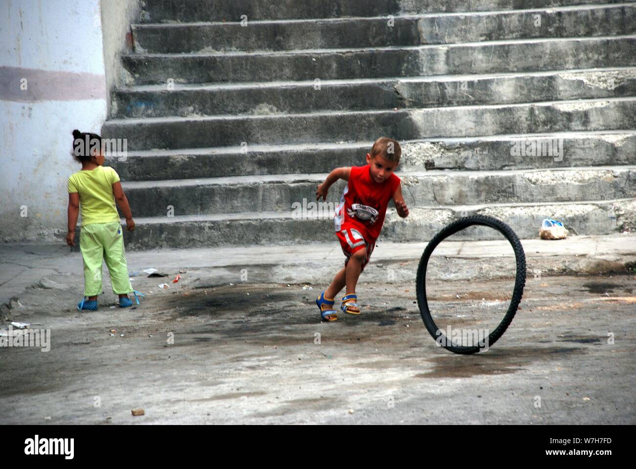 Kleinen kubanischen Jungen Jagt nach einem Fahrrad Rad Stockfoto