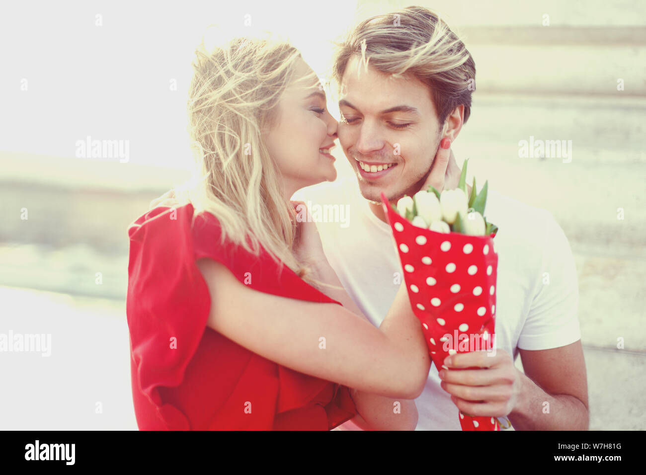 Glückliches junges Paar auf dating mit Blumenstrauß portrait Outdoor Stockfoto