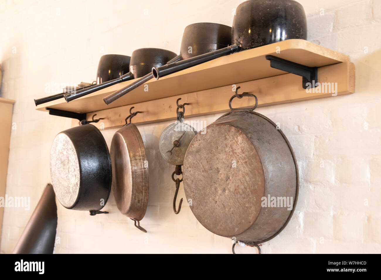 Vintage Töpfe und Pfannen an der Wand aufhängen, in einer alten Küche  Stockfotografie - Alamy