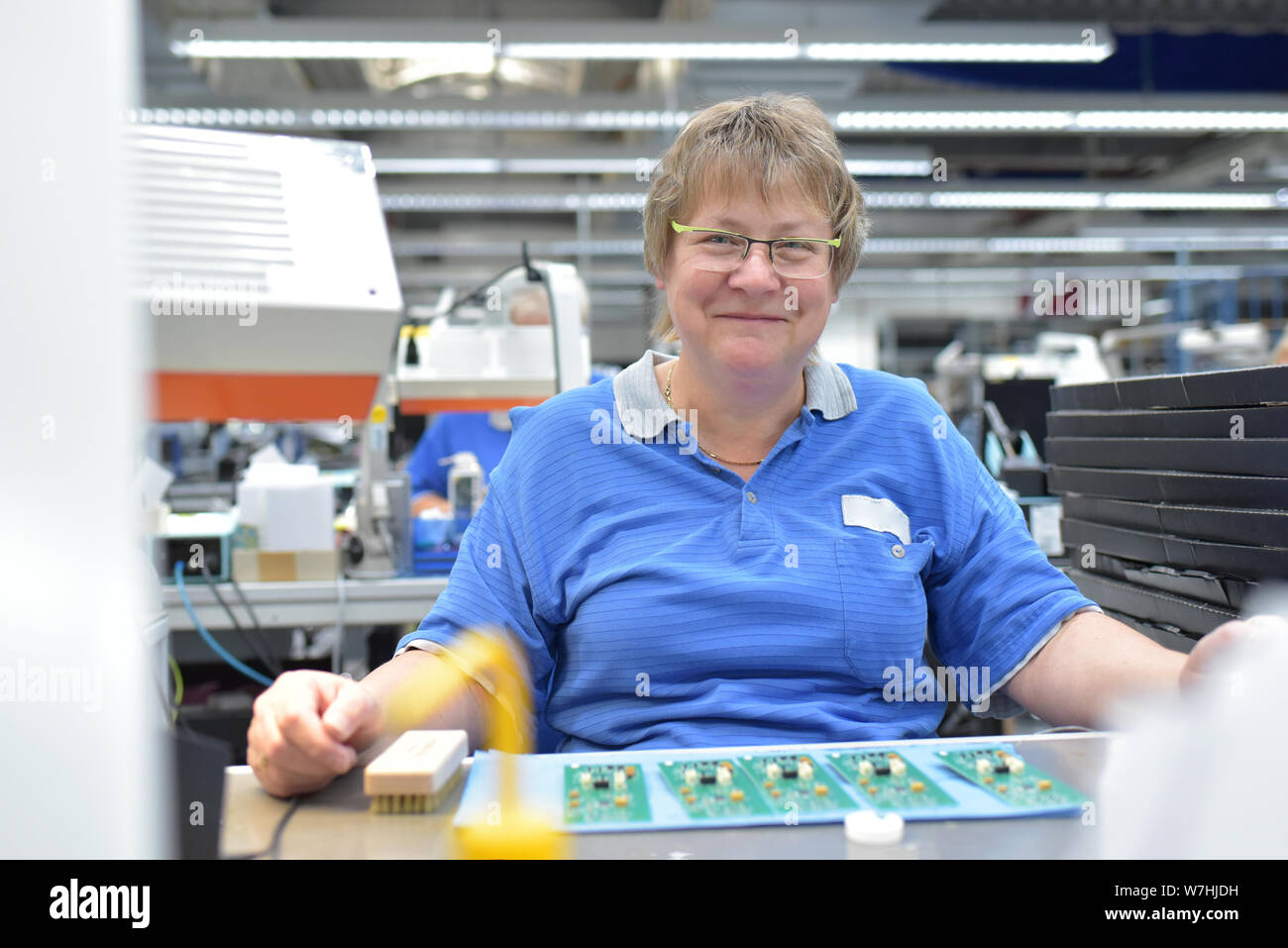 Freundliche Frau in einem mikroelektronikfertigung Factory-Komponenten Montage und Löten arbeiten Stockfoto