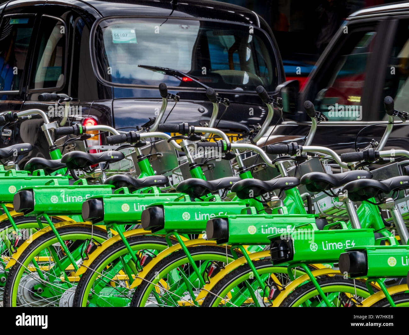 Kalk elektrische Fahrräder in London mit dem London Taxis im Hintergrund Stockfoto