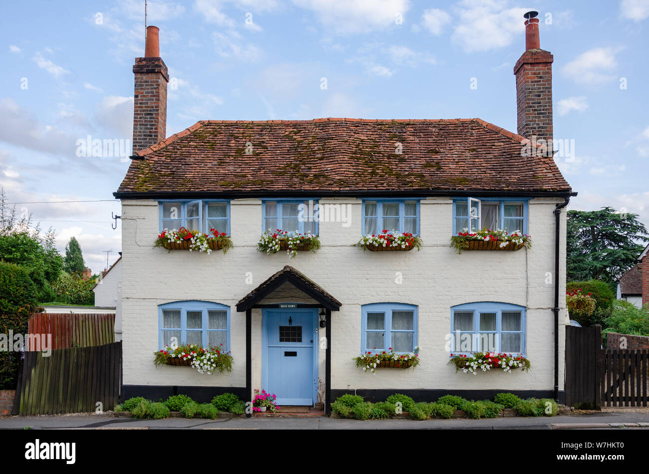 Eine attraktive Creme cottage in Pangbourne, West Berskshire, UK mit blauer Tür und Fenster und Blumenkästen. Stockfoto