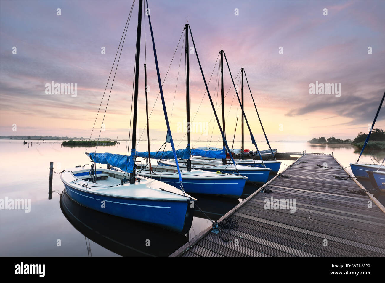 Nur wenige Yachten von Pier in der Morgendämmerung im Sommer, Niederlande Stockfoto