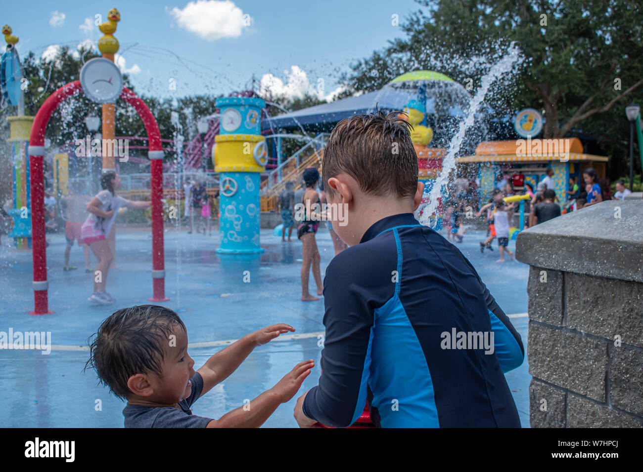 Orlando, Florida. Juli 30, 2019. Schönes Kind und kleinen Jungen spielen mit dem Wasserstrahl in Sesame Street in Seaworld Stockfoto