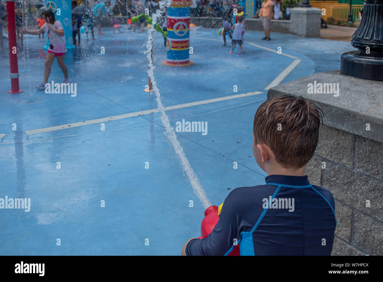 Orlando, Florida. Juli 30, 2019. Schöne junge spielt mit dem Wasserstrahl in Sesame Street in Seaworld Stockfoto