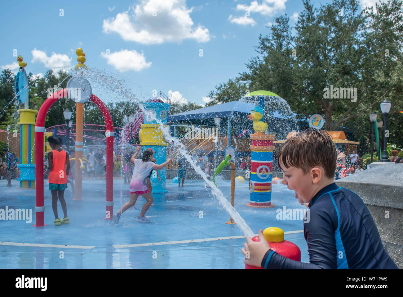 Orlando, Florida. Juli 30, 2019. Schöne junge spielt mit dem Wasserstrahl in Sesame Street in Seaworld Stockfoto