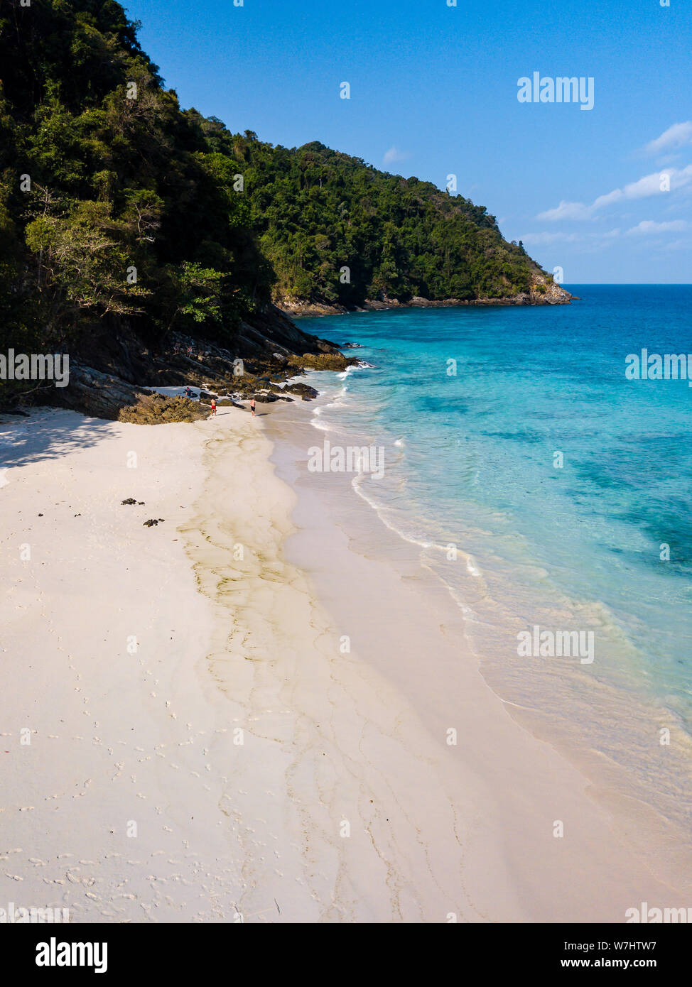 Antenne drone Blick auf einen wunderschönen Sandstrand von üppigen grünen Wald umgeben auf einer fernen tropischen Insel. Stockfoto