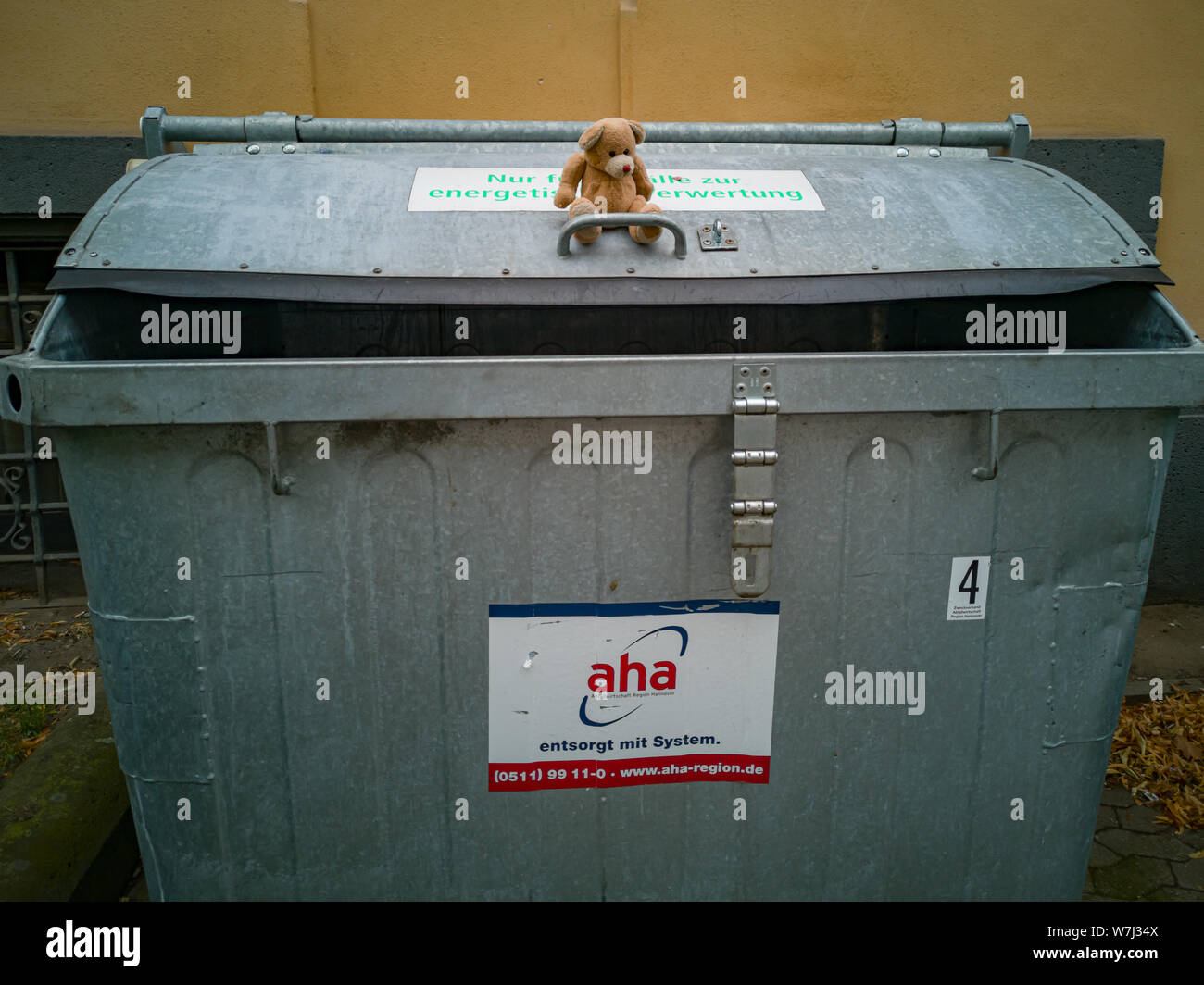 Hannover, Niedersachsen, Deutschland - Juli, 29, 2019: Ein einsamer kleiner Teddybär, sitzend auf einem Metall müll container Stockfoto