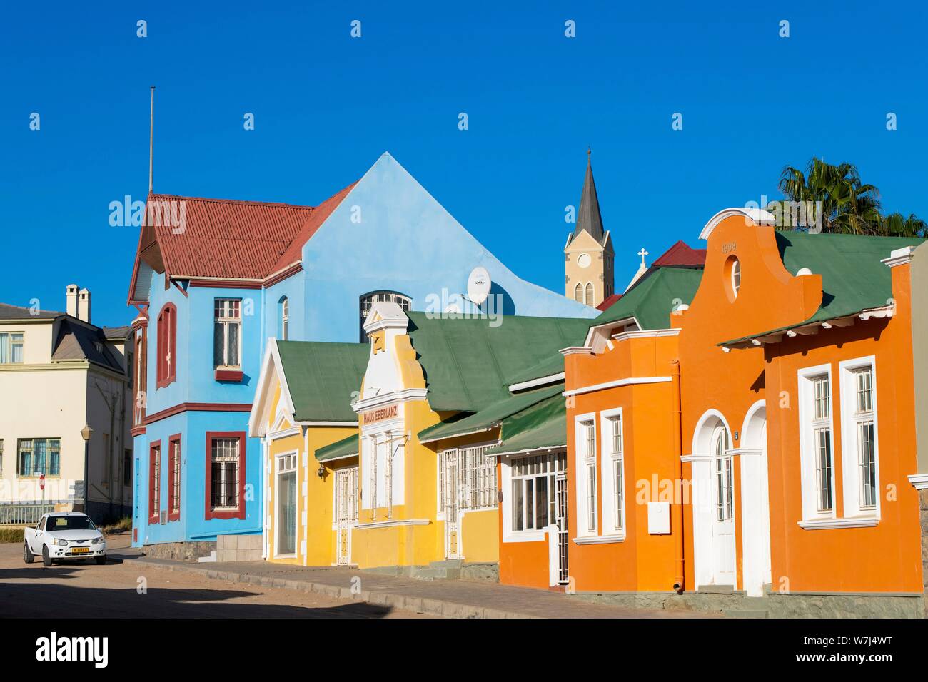 Bunte Häuser aus der deutschen Kolonialzeit, hinter dem Turm der Kirche, Altstadt von Lüderitz, Namibia Stockfoto