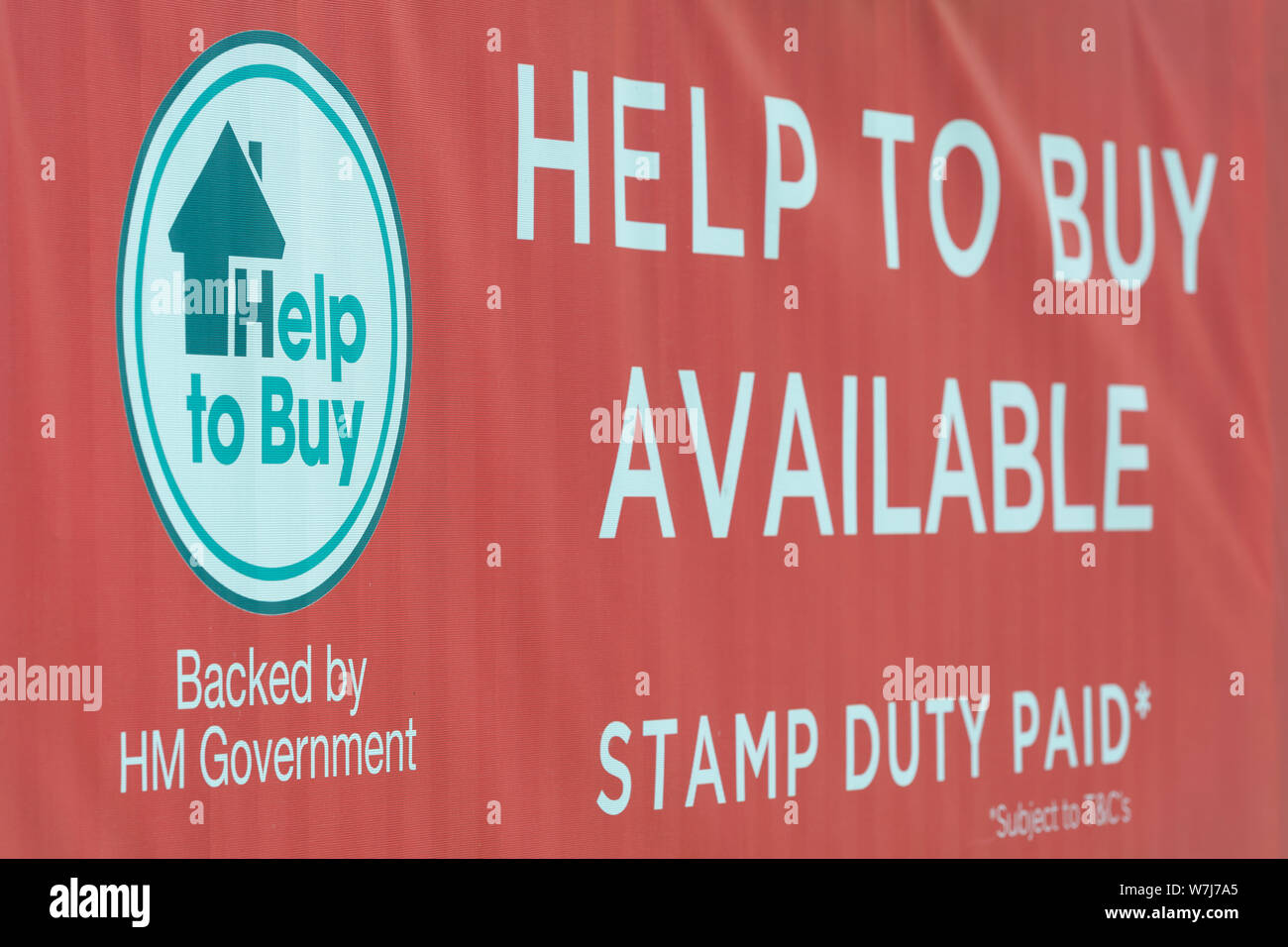 Signage Förderung der britischen Regierung Hilfe zu kaufen, in der Nähe der Neubauten Wohnungsbau entfernt. Stockfoto
