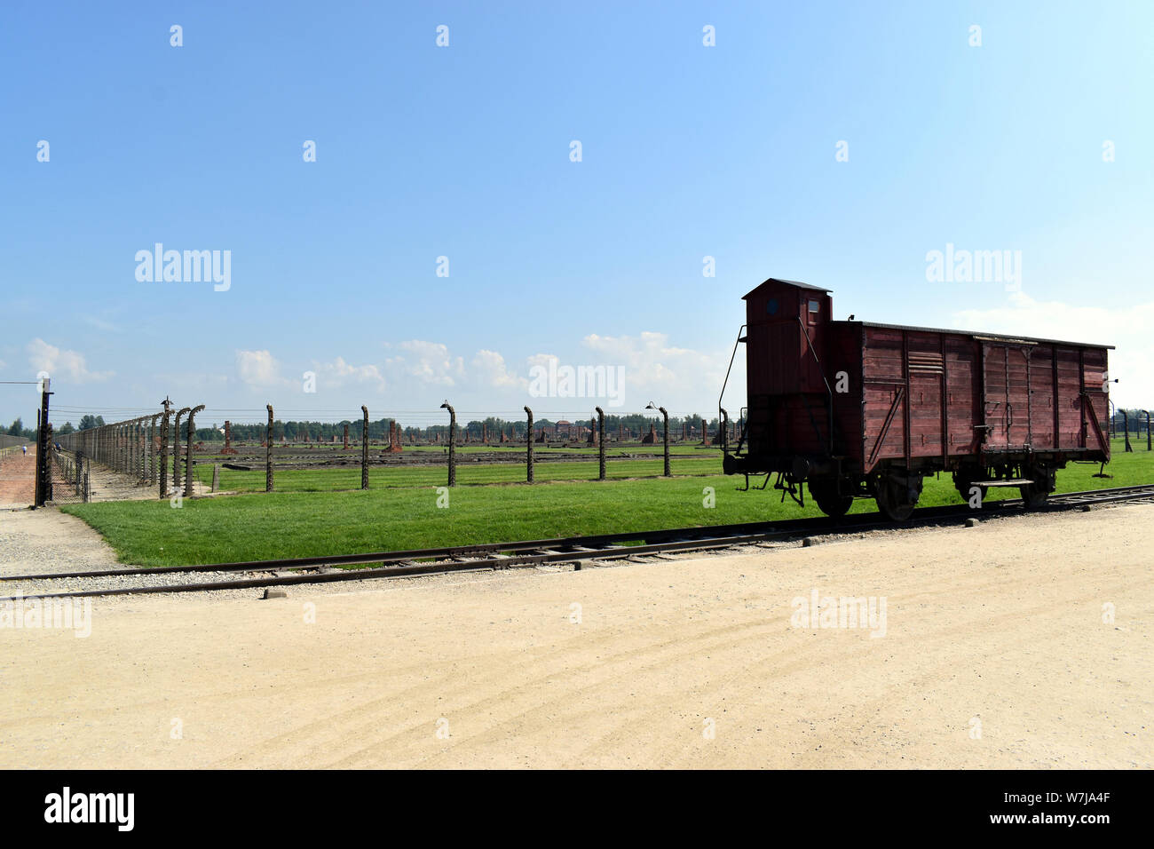: Ein Eingangstor in die abgerissen Unterkunft mit einem Eisenbahnwaggon auf die Schienen an der Birkenau Concentratio Stockfoto