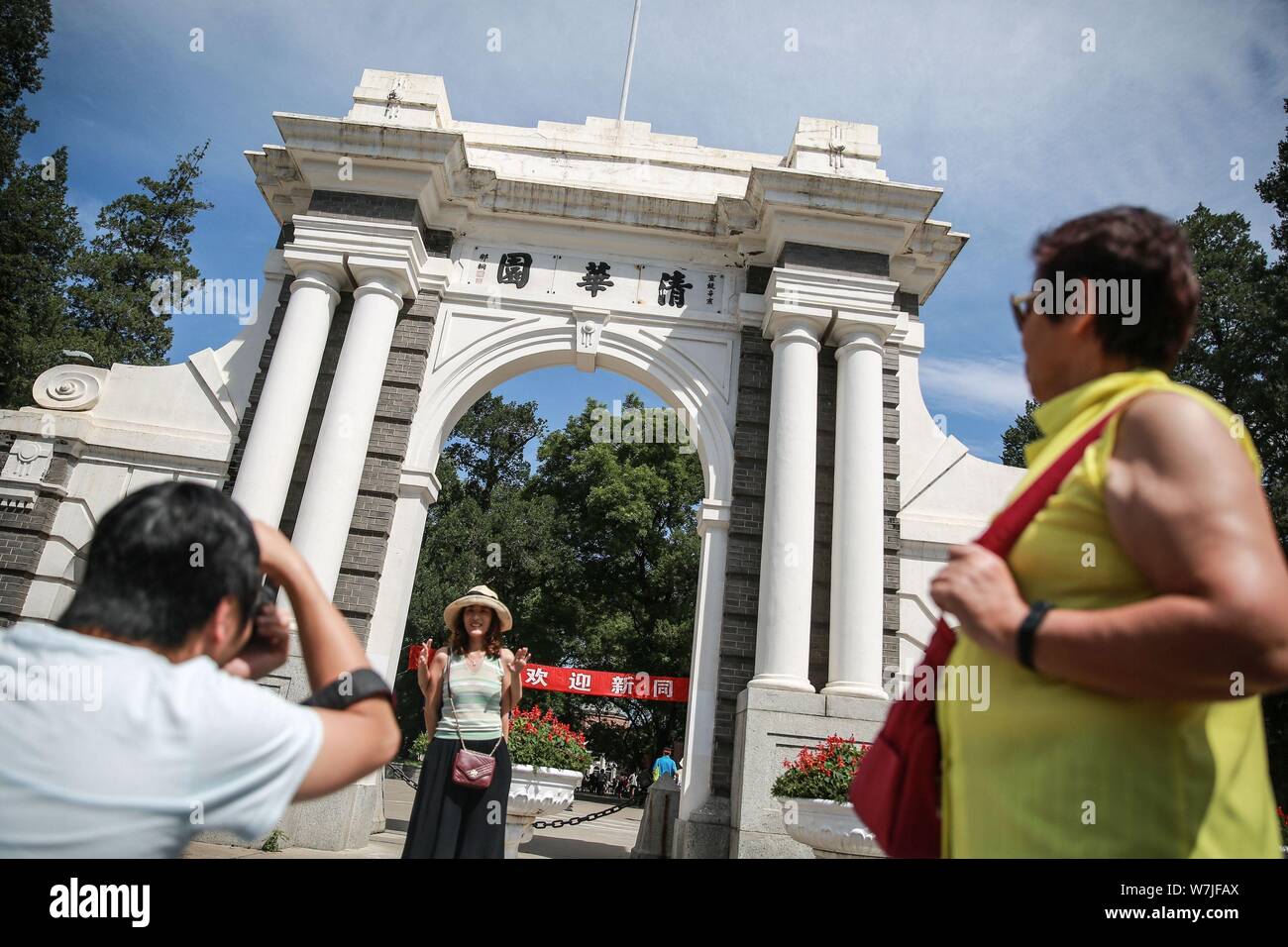 ---- Ein Besucher stellt für Fotos vor dem symbolischen Zweite Tor von der Tsinghua Universität in Peking, China, 25. August 2017. Chinesische authoritie Stockfoto