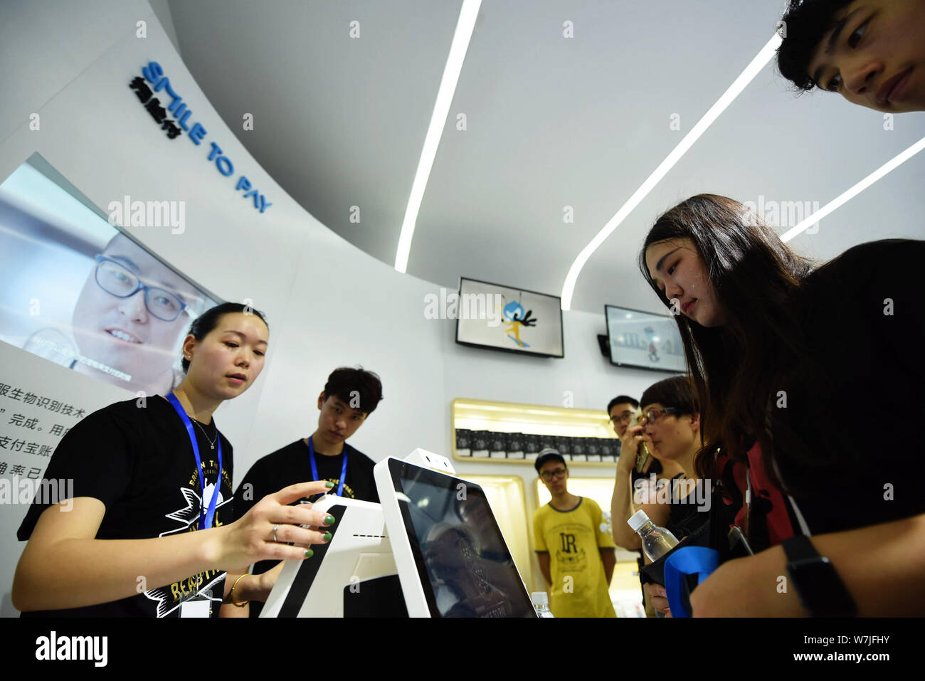 ---- Besucher probieren Sie den 'Smile' am Stand von Ant Finanzielle, eine Tochtergesellschaft der Chinesischen e-commerce Riese Alibaba Group, während einer exhibitio Stockfoto