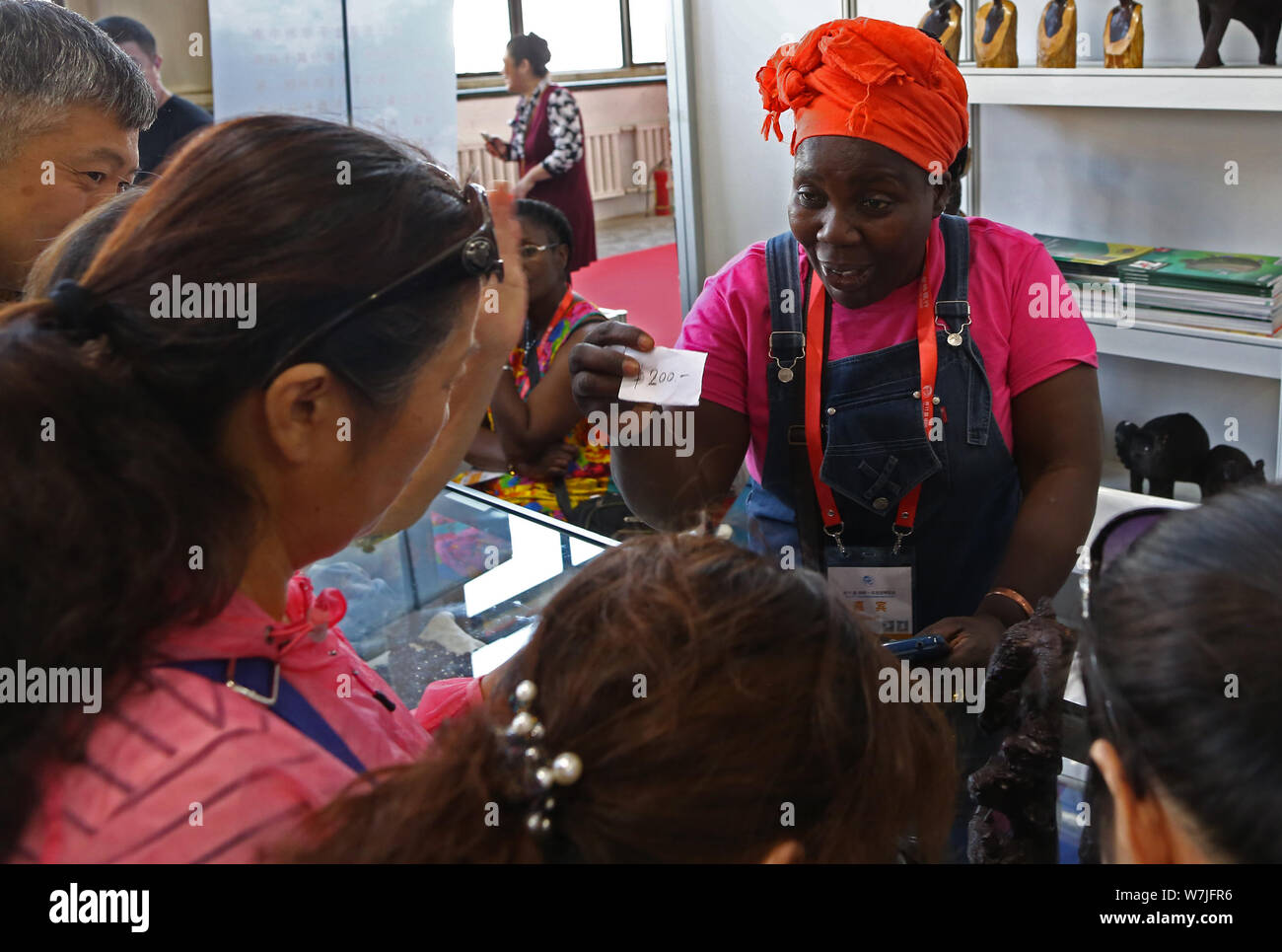 ---- Besucher drängen sich Kristalle am Stand von drei kenianischen Frauen während einer Messe in Changchun Stadt zu kaufen, im Nordosten Chinas in der Provinz Jilin, 2 Stockfoto