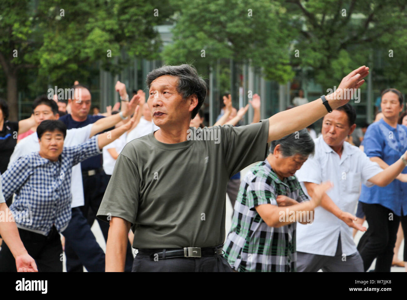 Chinesische Eltern üben Chinesischen Kung Fu von einem Meister eine halbe Stunde vor Beendigung der Schule Stau in einem Kindergarten in Zhengzhou City zu vermeiden, Stockfoto