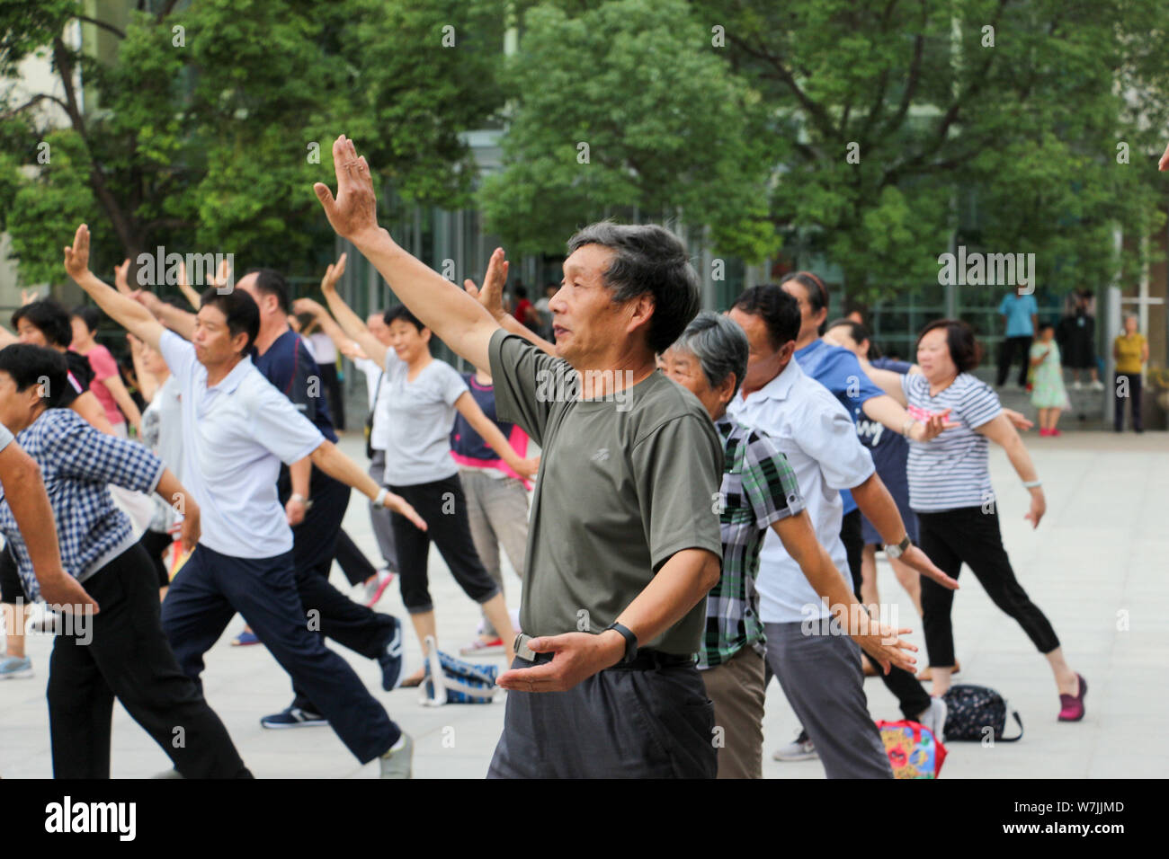 Chinesische Eltern üben Chinesischen Kung Fu von einem Meister eine halbe Stunde vor Beendigung der Schule Stau in einem Kindergarten in Zhengzhou City zu vermeiden, Stockfoto