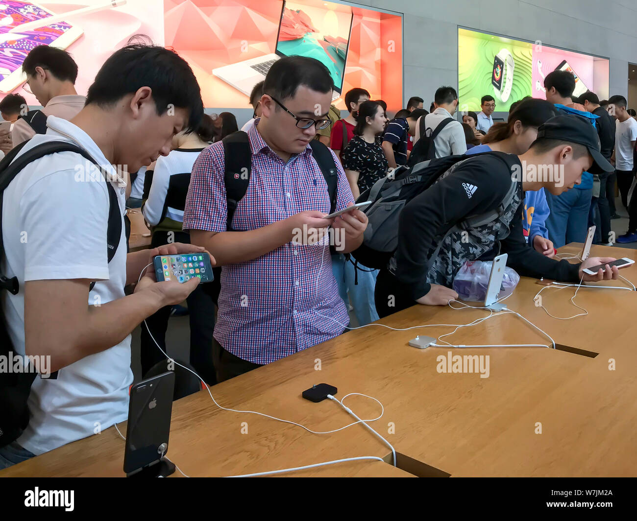 Chinesische Kunden versuchen, ein iPhone 8 und 8 Plus Smartphones im Apple Store auf der Einkaufsstraße Nanjing Road in Shanghai, China, 22. September 2 Stockfoto