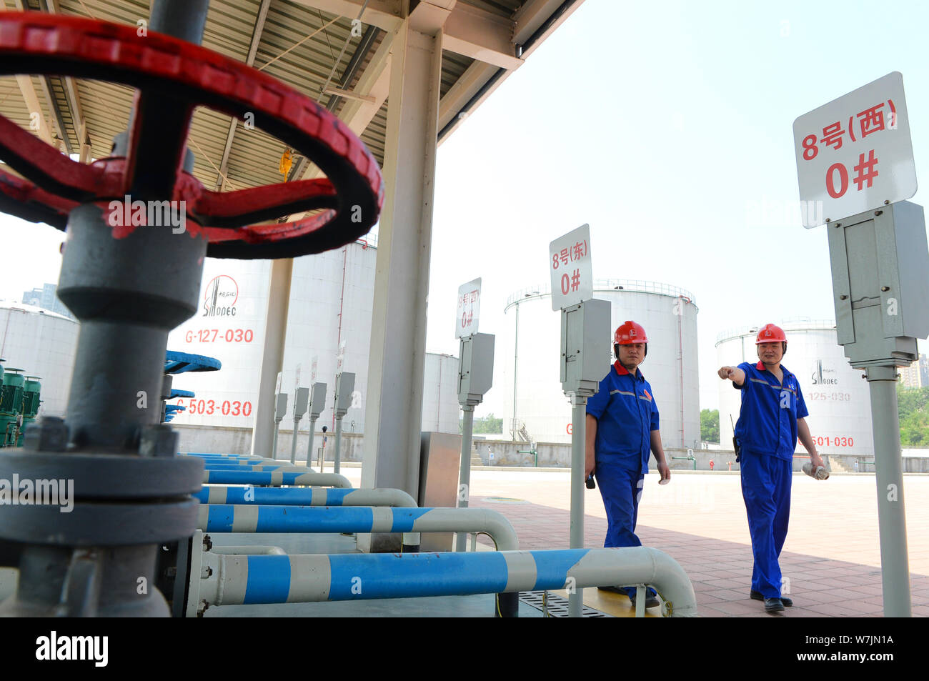 Die chinesischen Arbeiter Kraftstoffleitungen prüfen von ethanol Benzin und anderen Arten von Benzin an einer Tankstelle von Sinopec (China Petroleum & Chemical Corporation) in Stockfoto