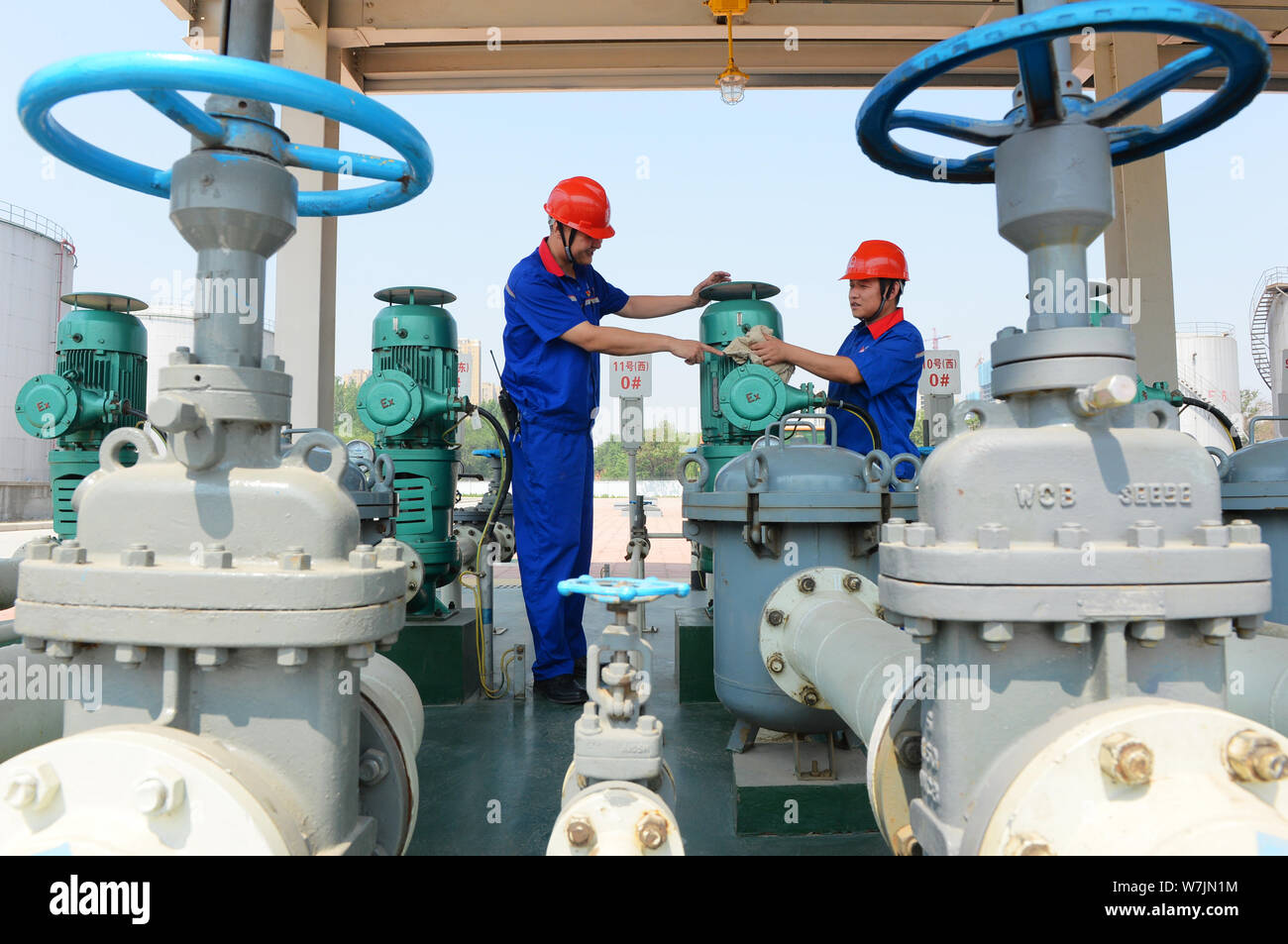 Die chinesischen Arbeiter Kraftstoffleitungen prüfen von ethanol Benzin und anderen Arten von Benzin an einer Tankstelle von Sinopec (China Petroleum & Chemical Corporation) in Stockfoto