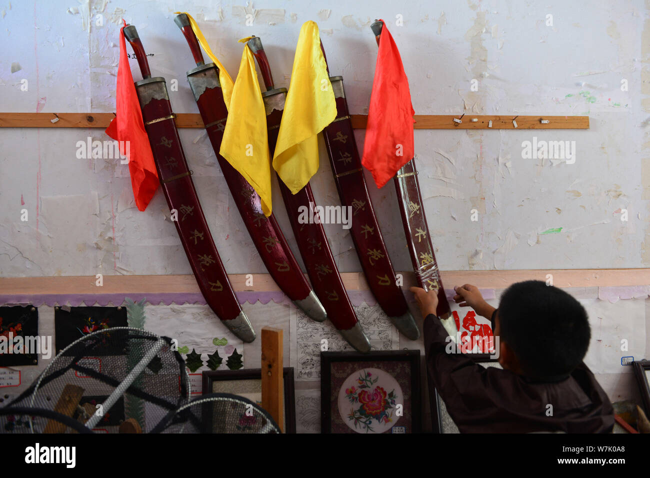 Ein Kind von Miao ethnische Gruppe nimmt eine Waffe an einem Arm Zimmer im County, Jianhe Qiandongnan Miao und Dong Autonomen Präfektur, Südwesten Chinas G Stockfoto