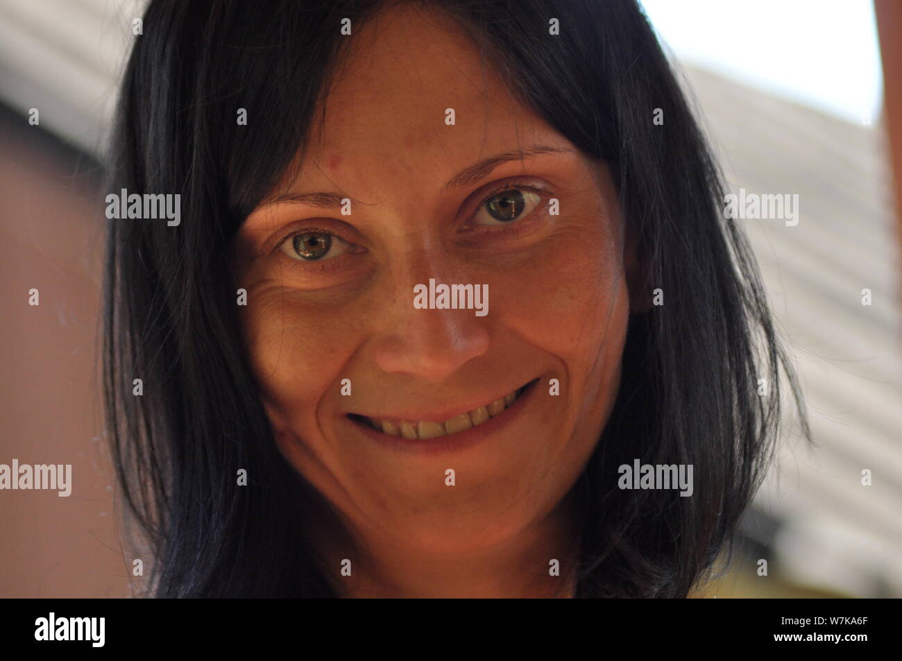 Die Frau unterhalten und nachdenklich. Mädchen mit Ohrringe. Lächeln und Zufriedenheit. Stockfoto