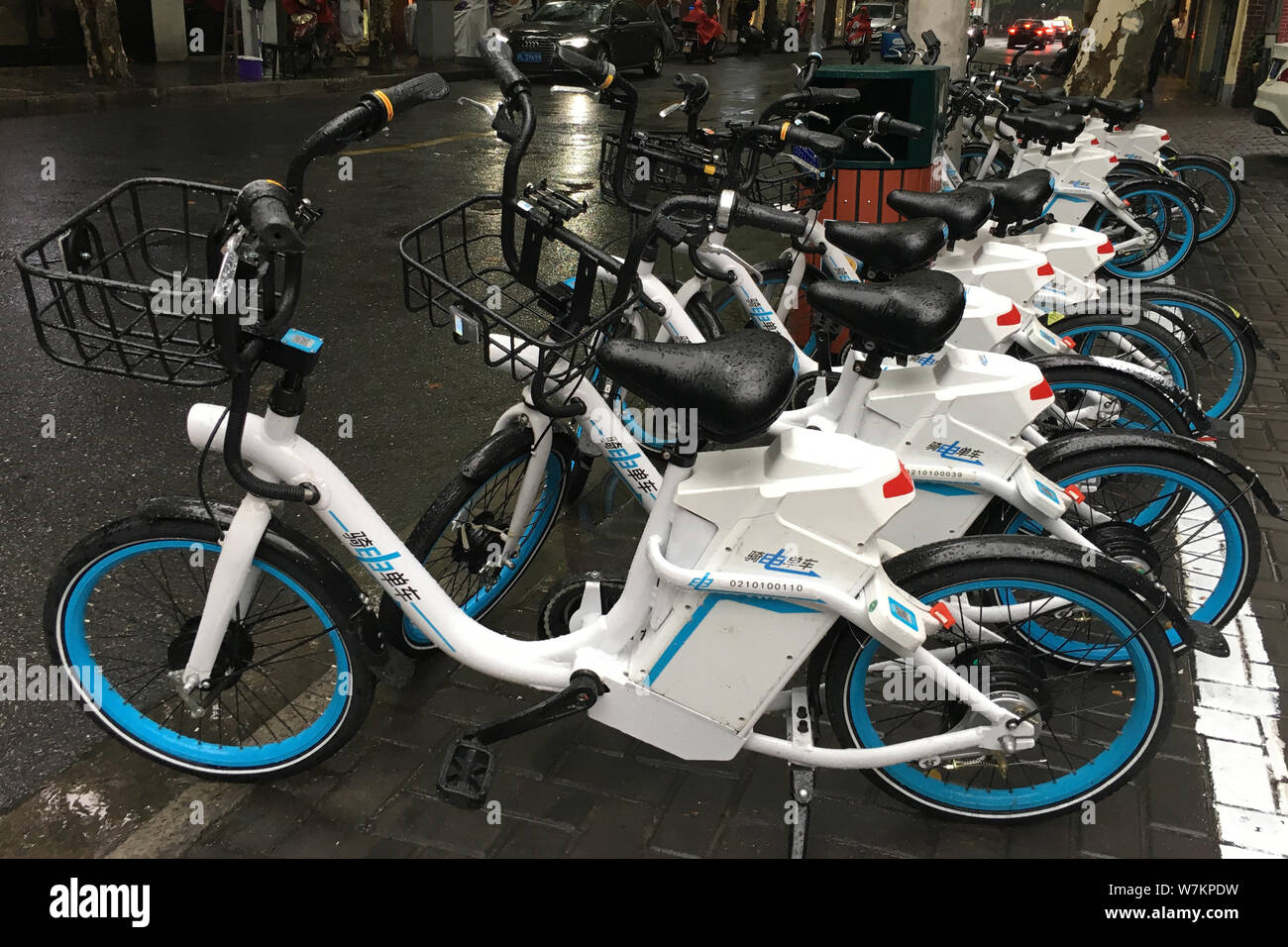 Fahrräder der Chinesischen e-bike-sharing service Qidian werden auf einer  Straße in Shanghai, China, 5. August 2017 gesäumt. Fahrräder der  Chinesischen elektrische bi Stockfotografie - Alamy