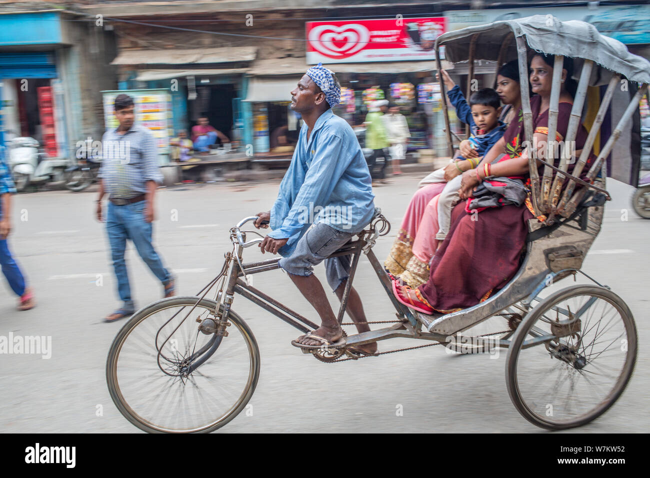 Ein Mann, sein Fahrrad Rikscha mit Kunden in der Innenstadt von Varanasi Stockfoto
