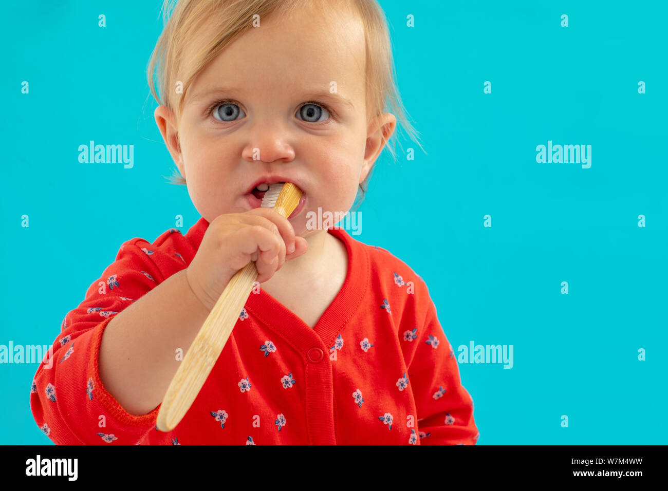 Kid in hellen Shirt mit Zahnbürste im Mund Stockfoto