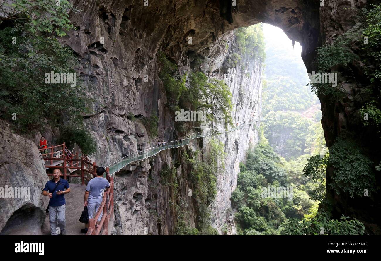 Touristen zu Fuß auf einem Glas - Plank Road entlang einer Felswand am Shimen Xianhu Scenic Area gebaut, Rongan County, Liuzhou, South China Guangxi Zhuang Stockfoto