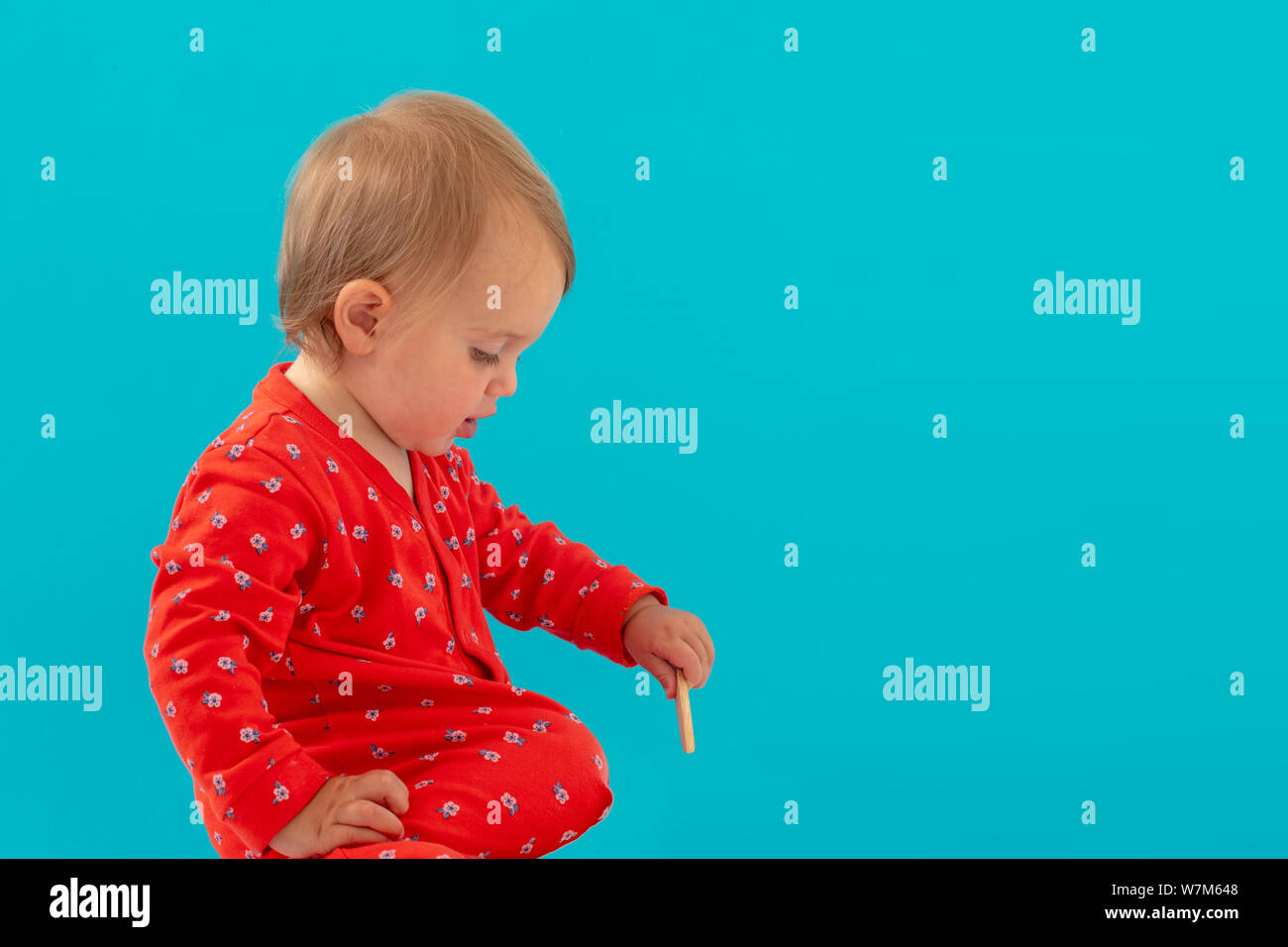 Kuriositäten Kind spielt mit Stick auf blauem Hintergrund Stockfoto