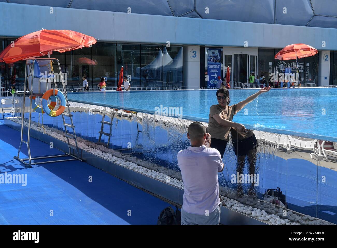 Die Besucher nehmen Sie Fotos mit einem 25 Meter langen und 15 Meter breiten Infinity-pool neben dem China National Aquatics Centre, besser bekannt als "Water Cube", i Stockfoto