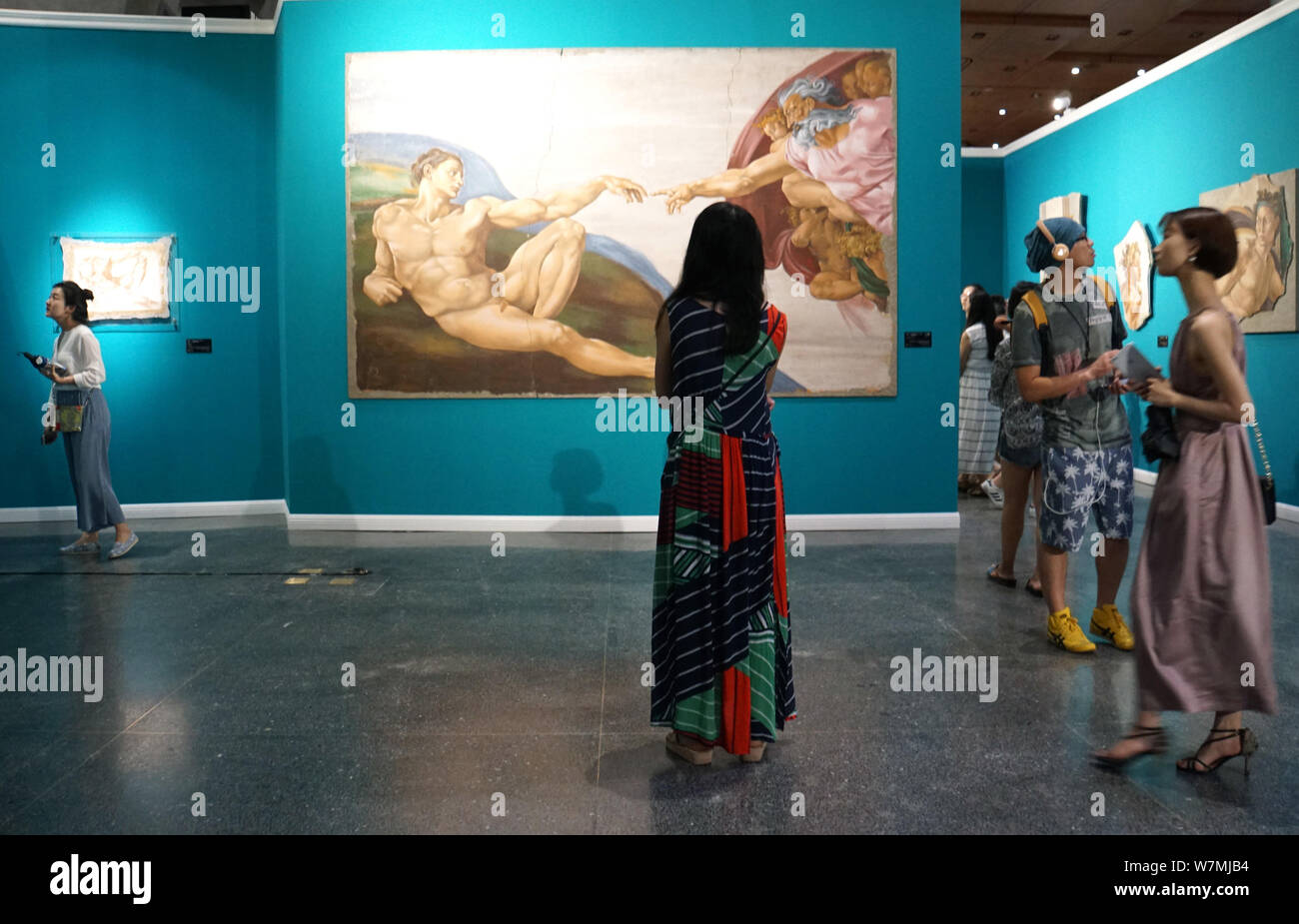 Besucher Blick auf einer replizierten Malerei von Michelangelos "Genesis - Erschaffung des Adam'' während der Göttliche Michelangelo Kunst Ausstellung in Peking, Kinn Stockfoto