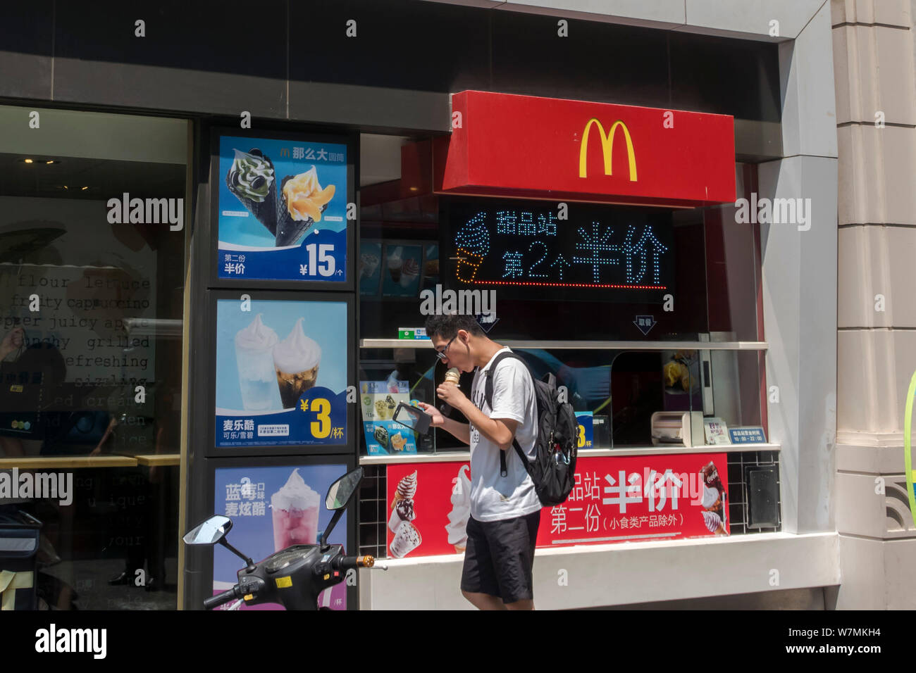 Ein Kunde isst ein Eis von McDonald's vor einem McDonald's Dessert Station in Shanghai, China, 27. Juli 2017. Virale Fotos und Nachrichten Stockfoto