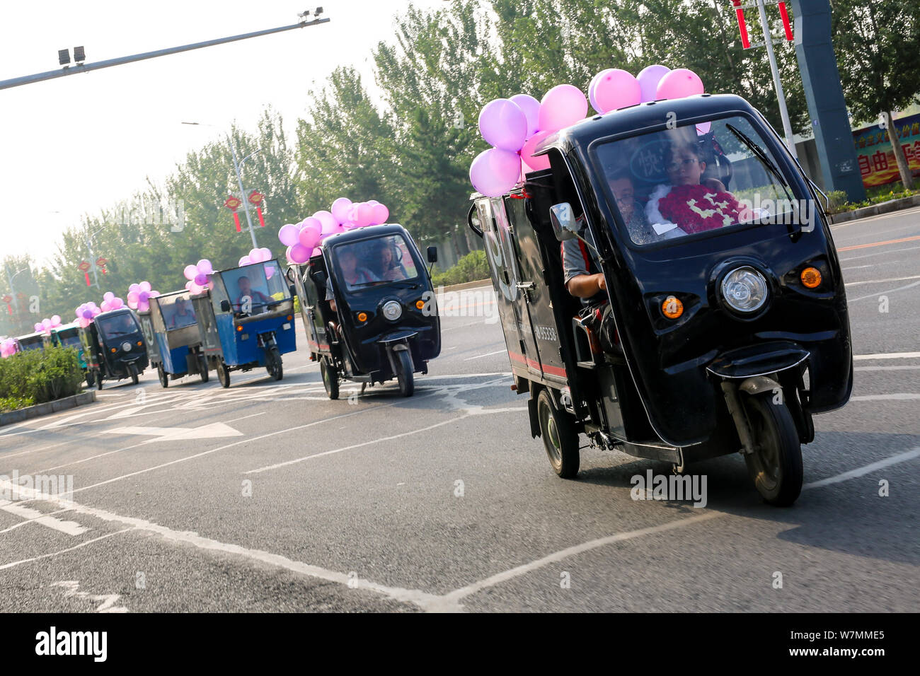 Die insgesamt 11 chinesische Lieferfahrzeuge Warteschlange eine fahrzeugkolonne Für einen Kurier zu bilden, wie er sich darauf vorbereitet, zu seiner Freundin, die er erhält, th Wissen vorschlagen Stockfoto