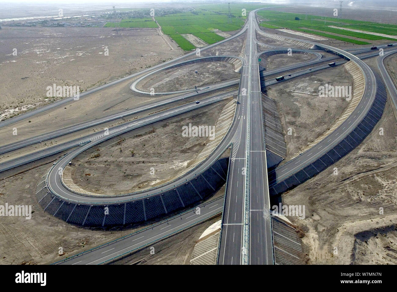 Luftaufnahme des Beijing-Urumqi Expressway, gemeinhin als Jingxin Expressway bekannt, durch die Wüste Gobi in Jiuquan Stadt im Nordwesten Chinas Gan Stockfoto