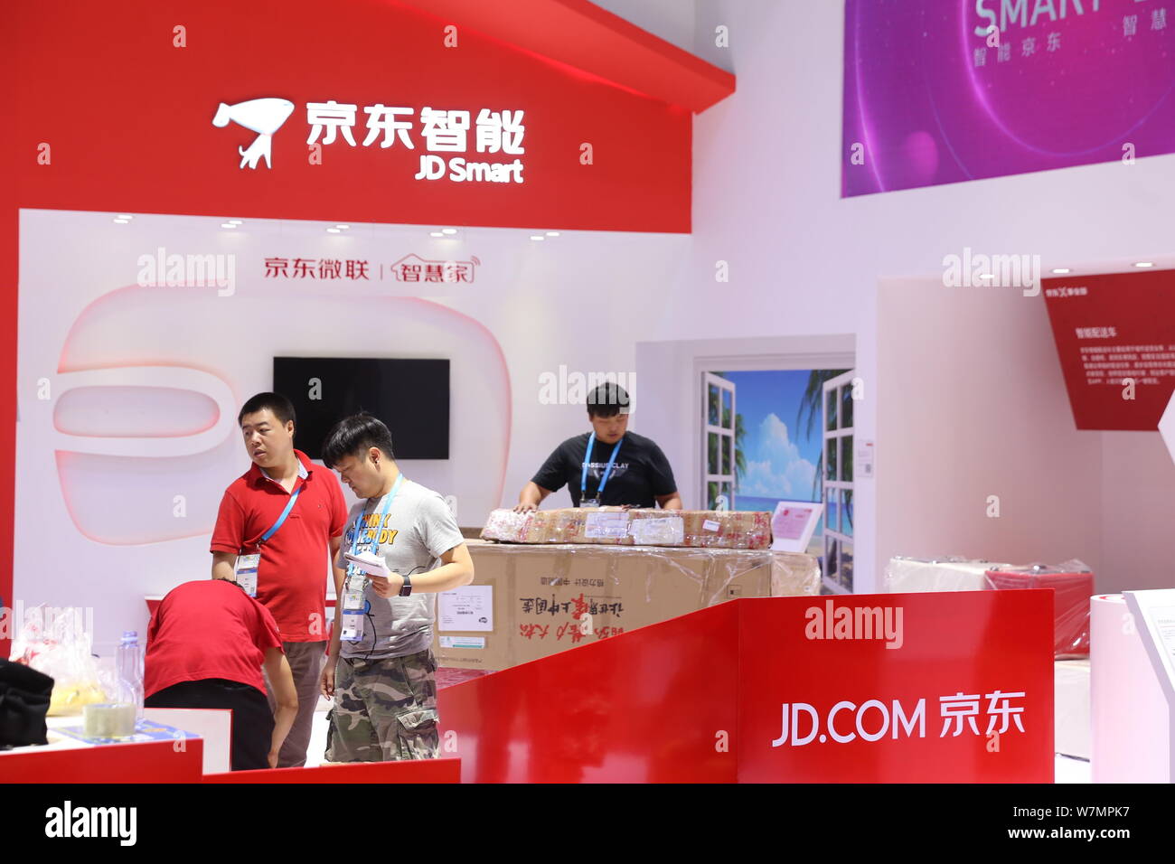 ------ Chinesische Mitarbeiter sind auf dem Stand von JD Smart e-commerce Plattform JD.com während einer Ausstellung in Shanghai, China, 7. Juni 2017. Stockfoto