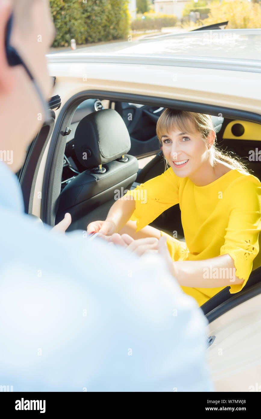 Taxifahrer helfen Frau Beifahrer aus dem Auto Stockfoto