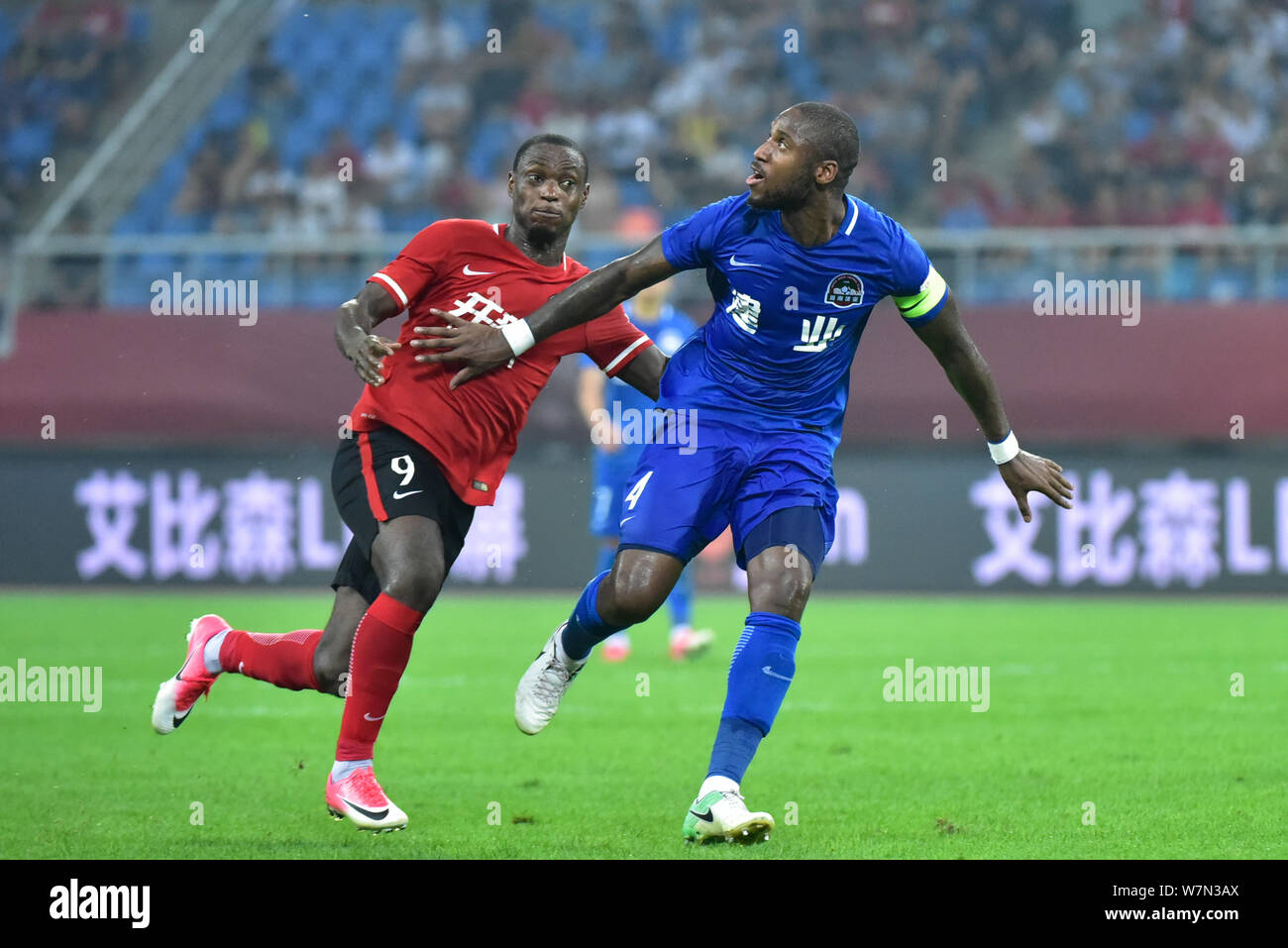 Bissau-Guinean Fußballspieler Edigeison Gomes, rechts, Henan Jianye, Herausforderungen nigerianischen Fußballspieler Anthony Ujah von Liaoning Whowin in Ihrer 1. Stockfoto