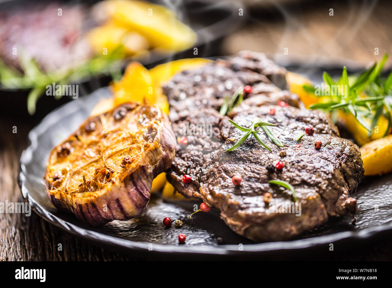 Gegrilltes Rindfleisch Rib Eye Steak mit Knoblauch amerikanische Kartoffeln Rosmarin Salz und Gewürze Stockfoto