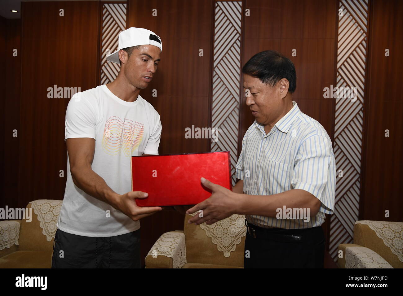 Portugiesische Fußballspieler Cristiano Ronaldo von Real Madrid, Links, sendet seine Fußballschuhe an Ma Chengquan, Vorsitzender der Chinese Super League (CSL), ein Stockfoto