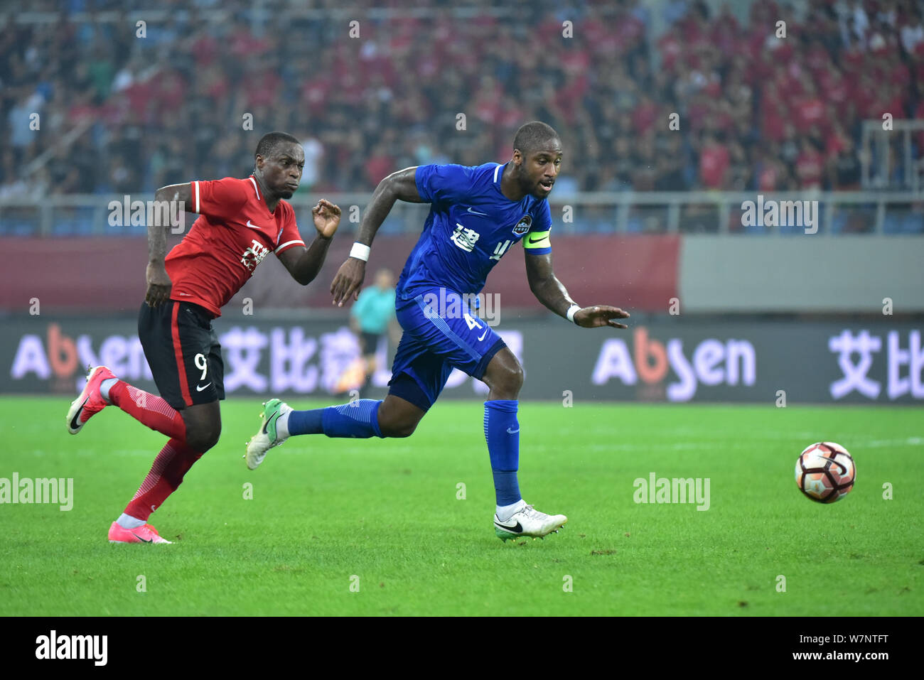 Bissau-Guinean Fußballspieler Edigeison Gomes, rechts, Henan Jianye, Herausforderungen nigerianischen Fußballspieler Anthony Ujah von Liaoning Whowin in Ihrer 1. Stockfoto