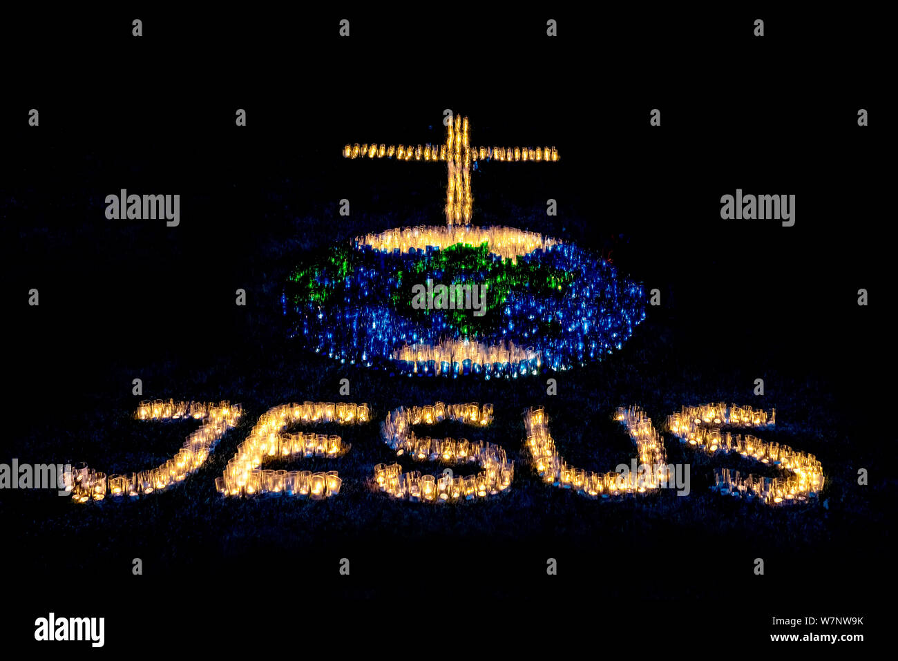 Religiöses Symbol mit Text Jesus und Kreuz aus Kerzen gebildet Stockfoto