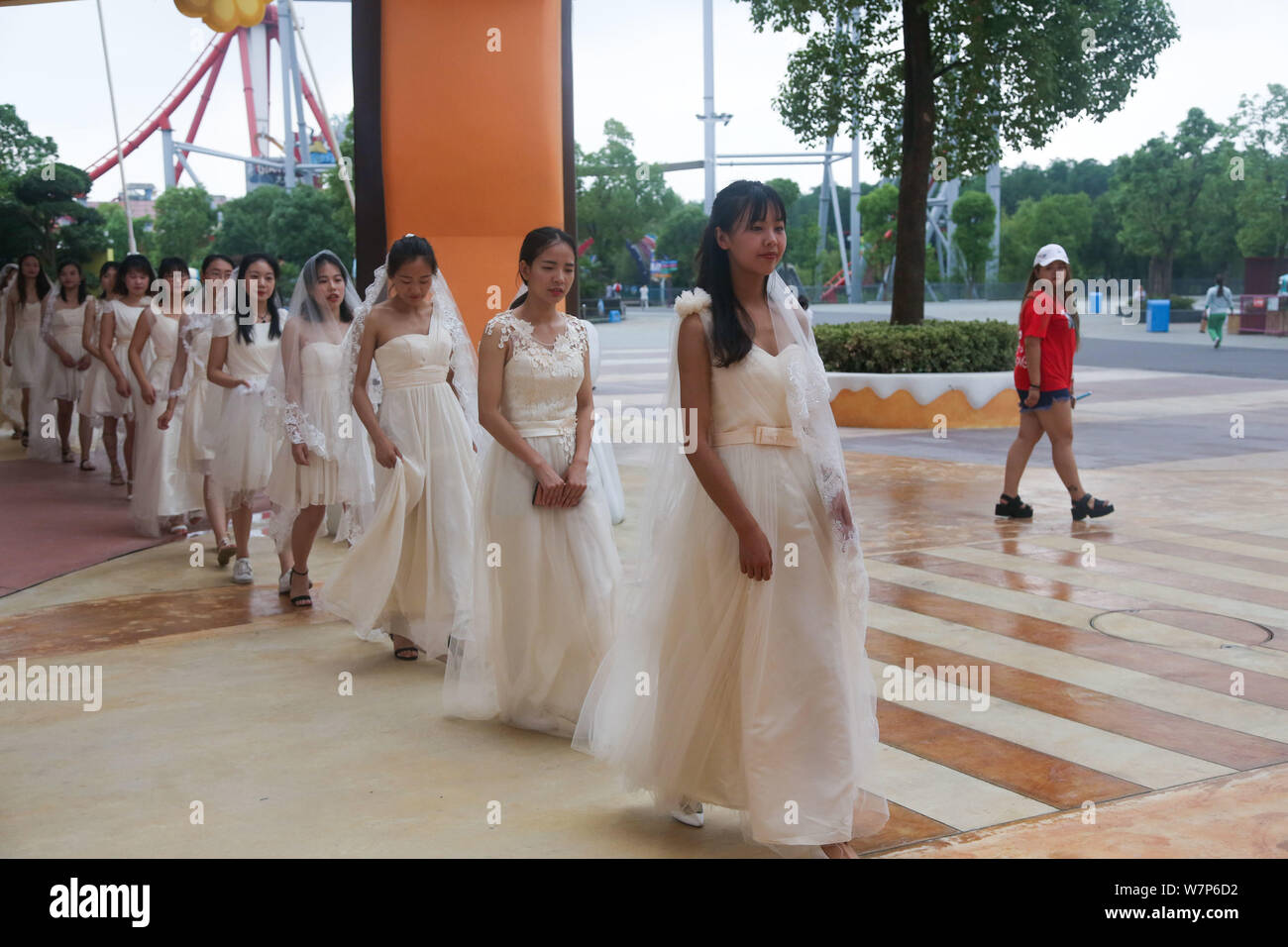 Bräute Brautkleider sind eine Gruppe Trauung für Paare der schulfreund Liebhaber aus einer Universität Wuhan Happy Valley Amusement Park gesehen Stockfoto