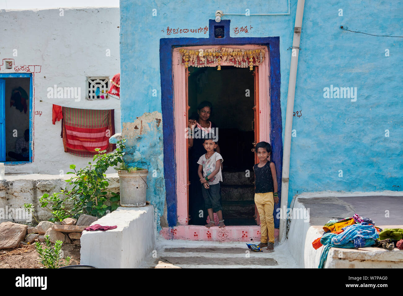 Typisches Dorf Szene mit 3 Personen vor der Haustür in Aihole, Karnataka, Indien Stockfoto