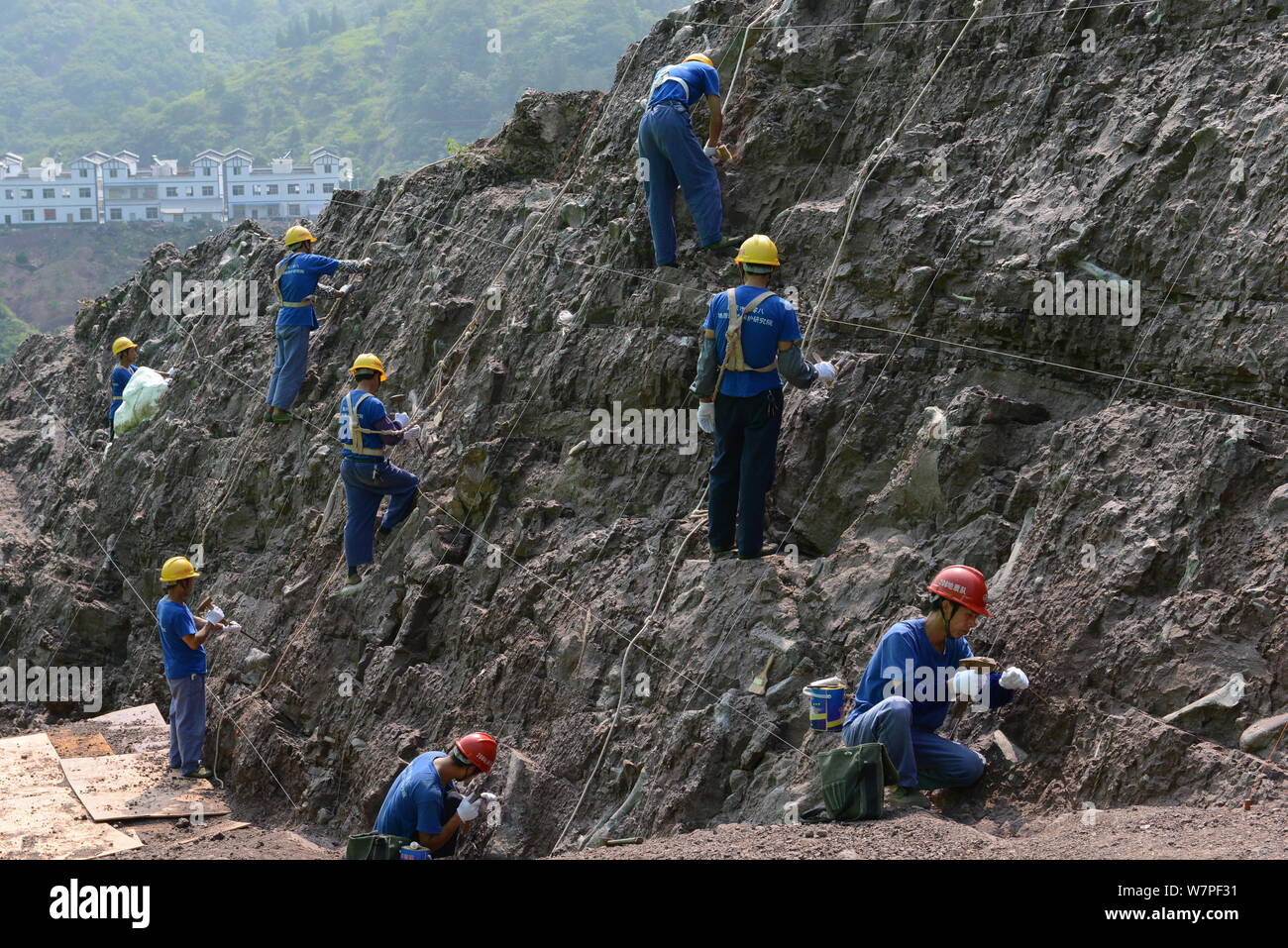 Chinesische Arbeiter auszugraben Dinosaurier Fossilien in einer Wand 150 Meter lang, 2 Meter tief und 8 Meter hoch, an der Ausgrabungsstätte in Laojun vi konzentriert Stockfoto