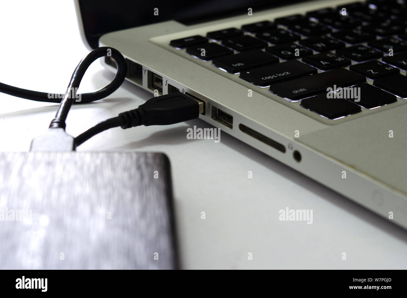 Externe Festplatte an den Laptop auf den weißen Hintergrund. Stockfoto