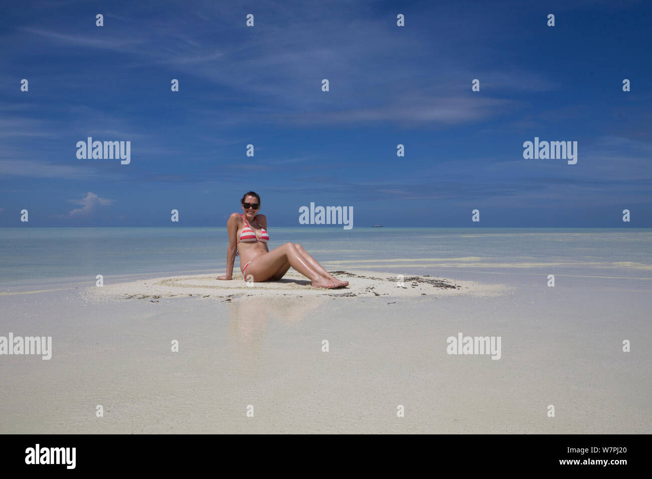 Touristische Sonnenbaden auf winzigen Sand Island, im Meemu Atoll, Malediven. Dezember 2009. Model Released. Stockfoto