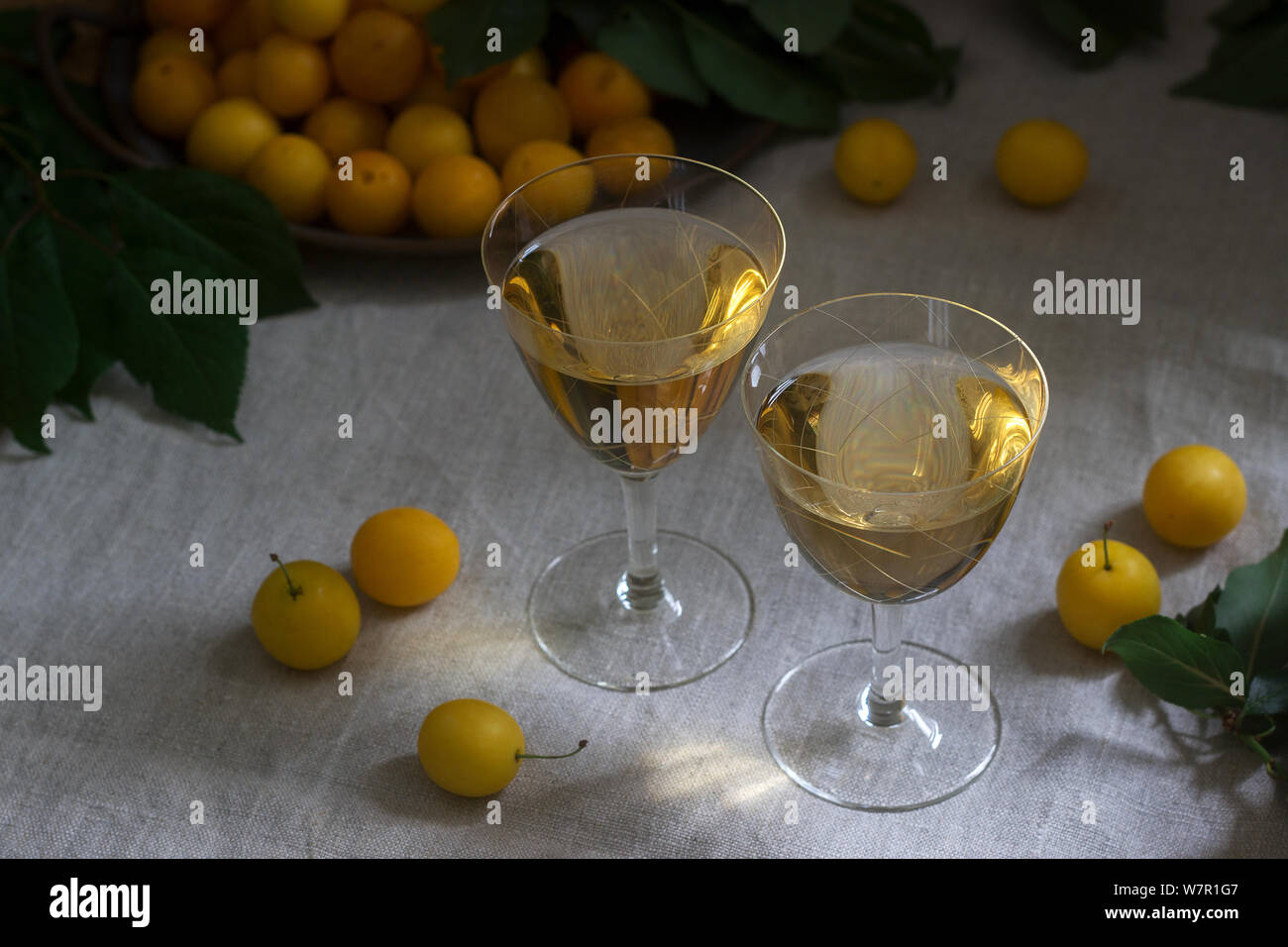Cherry Plum Likör in kleinen Gläsern und Cherry Plum auf einer hölzernen Hintergrund. Im rustikalen Stil. Stockfoto