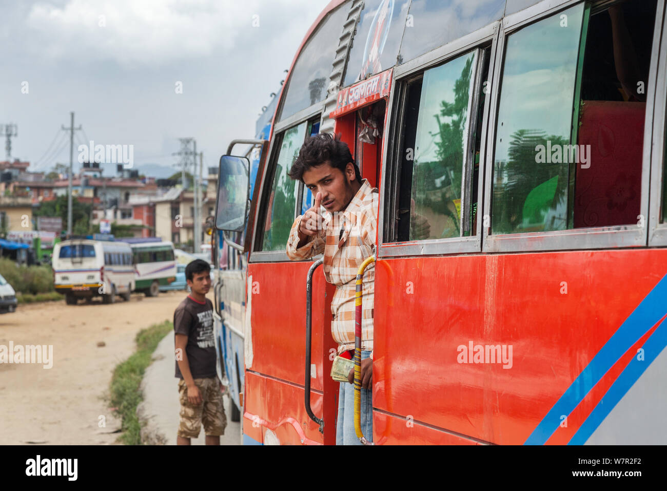 Bus Ticket Collector mit seinem Daumen hoch, traten an die Tür des Busses in Kathmandu Stockfoto