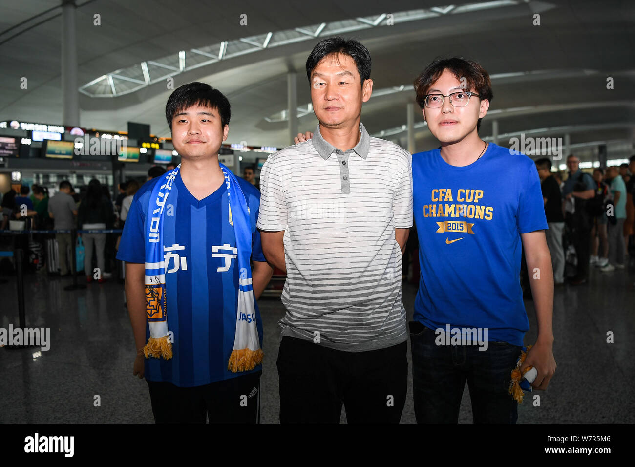 Ehemaliger Haupttrainer Choi Yong-soo von Jiangsu Suning, Mitte, wirft mit Fans vor der Rückkehr nach Südkorea an der Nanjing Lukou Flughafen Stockfoto